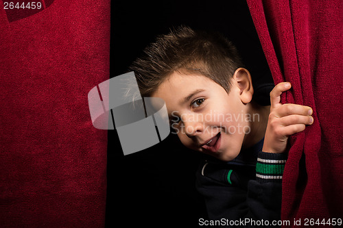 Image of Child appearing beneath the curtain