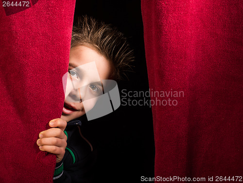 Image of Child appearing beneath the curtain