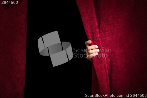 Image of Hand appearing beneath the curtain.