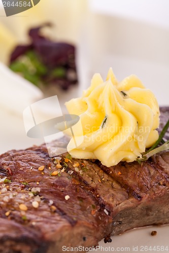 Image of Grilled beef steak topped with butter and rosemary