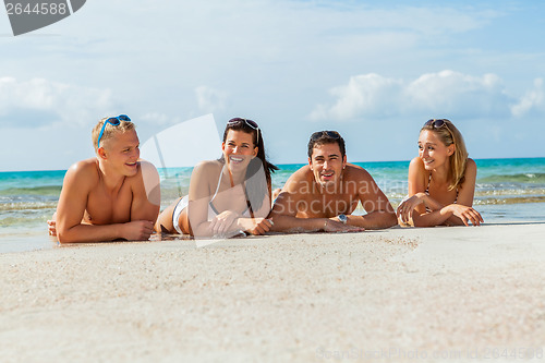 Image of young happy friends havin fun on the beach