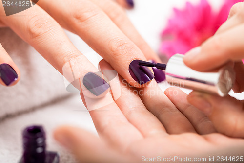 Image of Woman having a nail manicure in a beauty salon