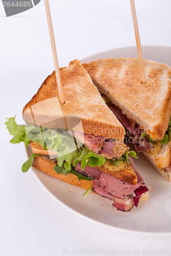 Image of Delicious pastrami club sandwich and pickles