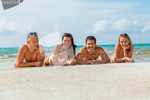 Image of young happy friends havin fun on the beach