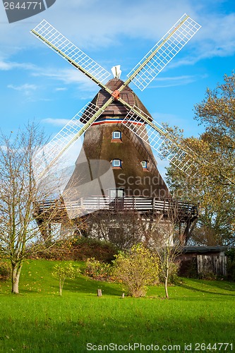 Image of Traditional wooden windmill in a lush garden