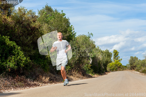 Image of athletic man runner jogging in nature outdoor