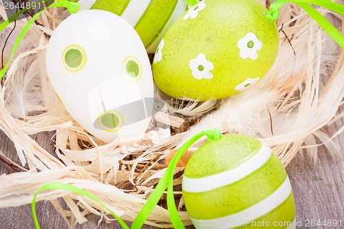 Image of Colourful green Easter eggs in straw