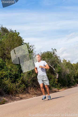 Image of athletic man runner jogging in nature outdoor