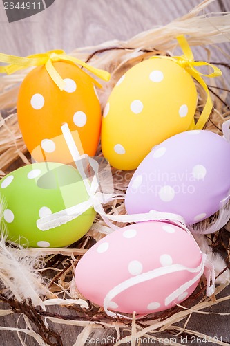 Image of colorful easter egg decoration on wooden background