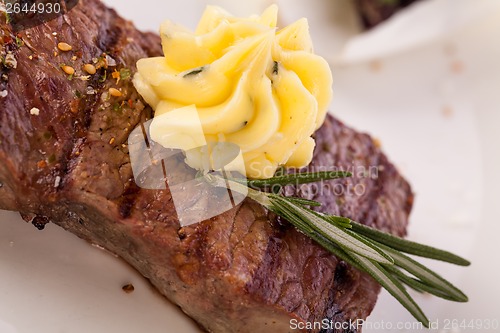 Image of Grilled beef steak topped with butter and rosemary