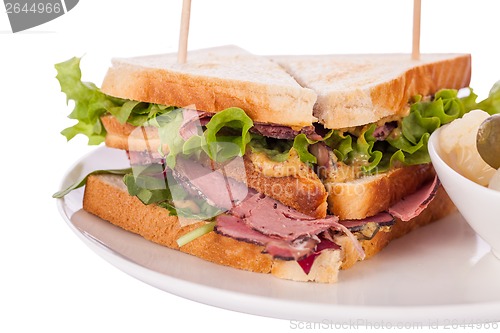 Image of Delicious pastrami club sandwich and pickles