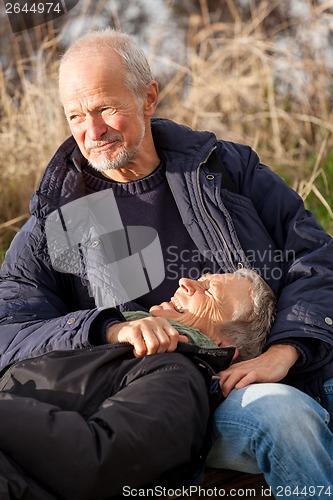 Image of happy senior couple relaxing together in the sunshine