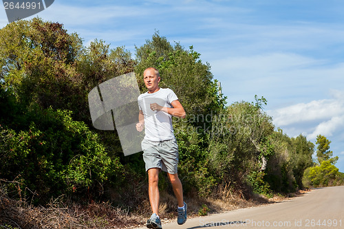 Image of athletic man runner jogging in nature outdoor