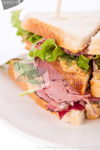 Image of Delicious pastrami club sandwich and pickles