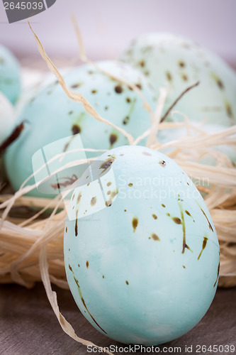 Image of Three natural blue Easter eggs in a basket