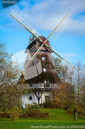 Image of Traditional wooden windmill in a lush garden