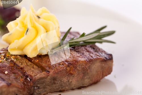 Image of Grilled beef steak topped with butter and rosemary