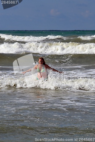 Image of The woman in the sea against big waves.