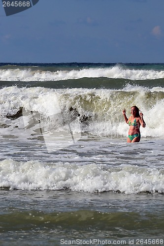Image of The woman in the sea against big waves.