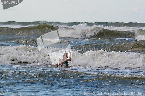 Image of The woman in the sea against big waves.