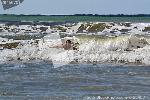 Image of The woman in the sea against big waves.