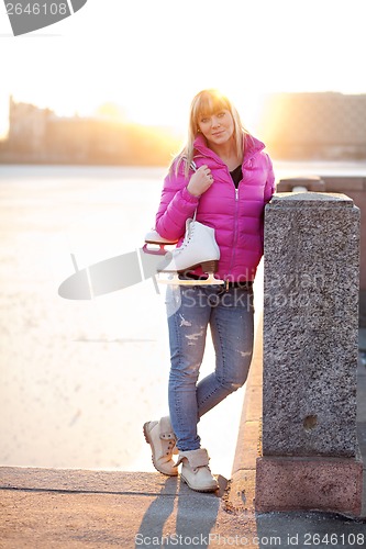 Image of Blond woman standing with ice skates