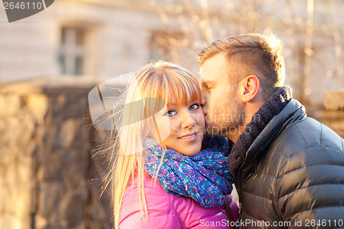 Image of Young man kissing a beautiful woman