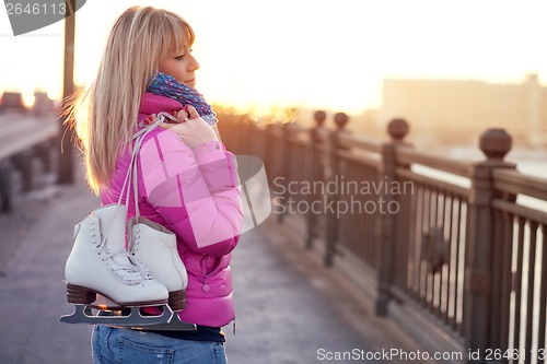 Image of Beautiful young blond woman walking on bridge