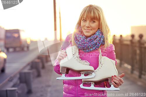 Image of Beautiful smiling blond woman with ice skates