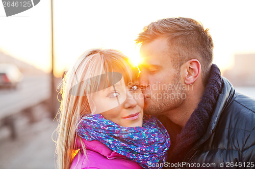 Image of Young man kissing a beautiful woman