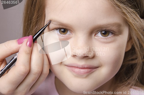 Image of Makeup artist brings eyebrows on the girl's face