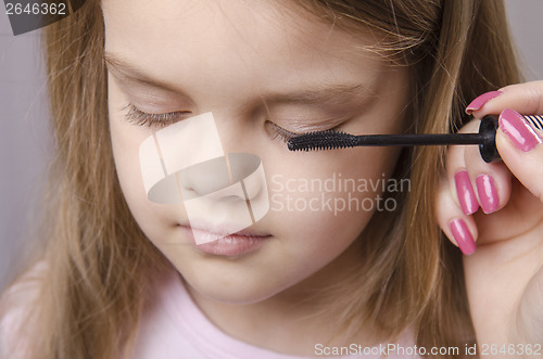 Image of Makeup artist paints eyelashes on girl's face
