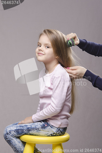 Image of Hairdresser brushing her long hair girls