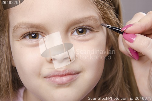 Image of Makeup artist brings eyebrows on the girl's face