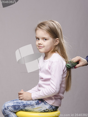 Image of Hairdresser brushing her long hair girls