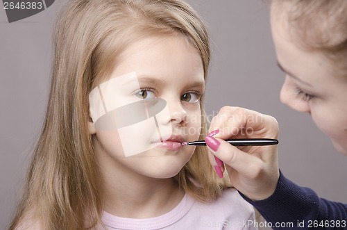 Image of Makeup artist paints her lips girls
