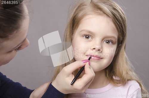 Image of Makeup artist paints her lips girls