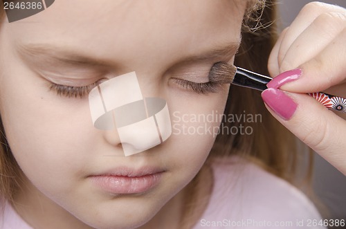 Image of Makeup artist paints eyelids on girl's face