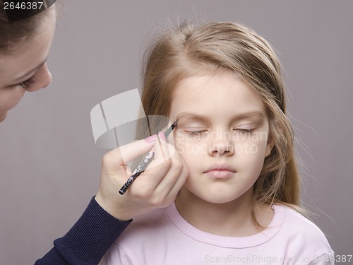 Image of Makeup artist brings eyebrows on the girl's face