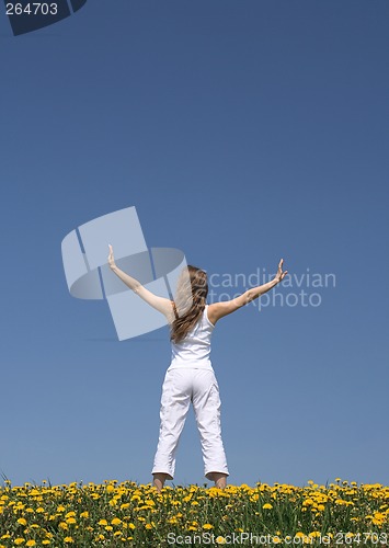 Image of Young woman exercising in dandelion field