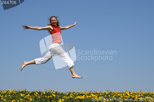 Image of Girl flying in a jump over dandelion field