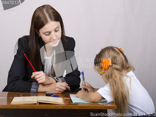 Image of  teacher teaches lessons with student sitting at table