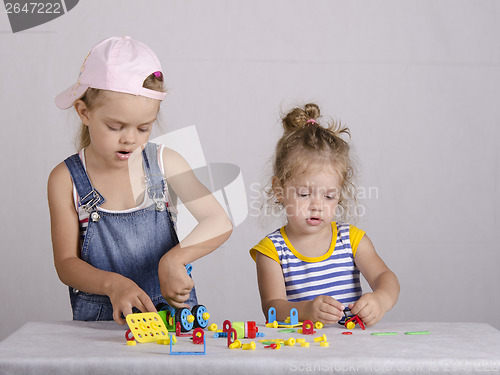 Image of Two children play in the constructor