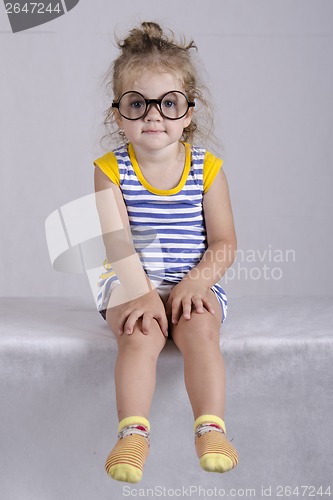 Image of Two-year-old girl funny glasses sitting looking in frame