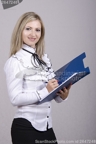 Image of Working girl writes on sheet folder and look in frame