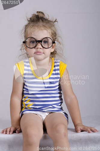 Image of Two-year-old girl funny glasses sitting looking in frame