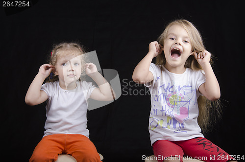 Image of Portrait of sisters, and two little girls, have joined hands behind ears