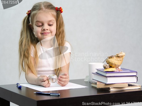 Image of girl thoughtfully and effortlessly turns glass globe