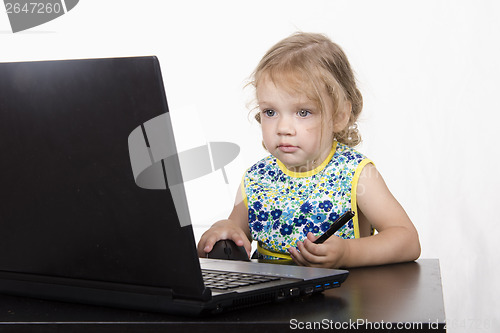 Image of girl working at a laptop and looked mysteriously in frame