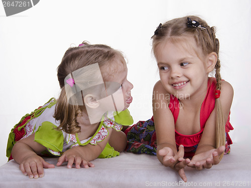 Image of Two girls lie, one tongue, the other smiles